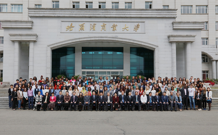 主席台的领导和来宾为新生佩带哈尔滨商业大学校徽,34位硕士研究生将