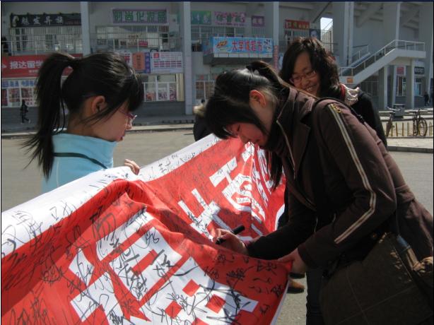 同学们在征集祝福的条幅上签名